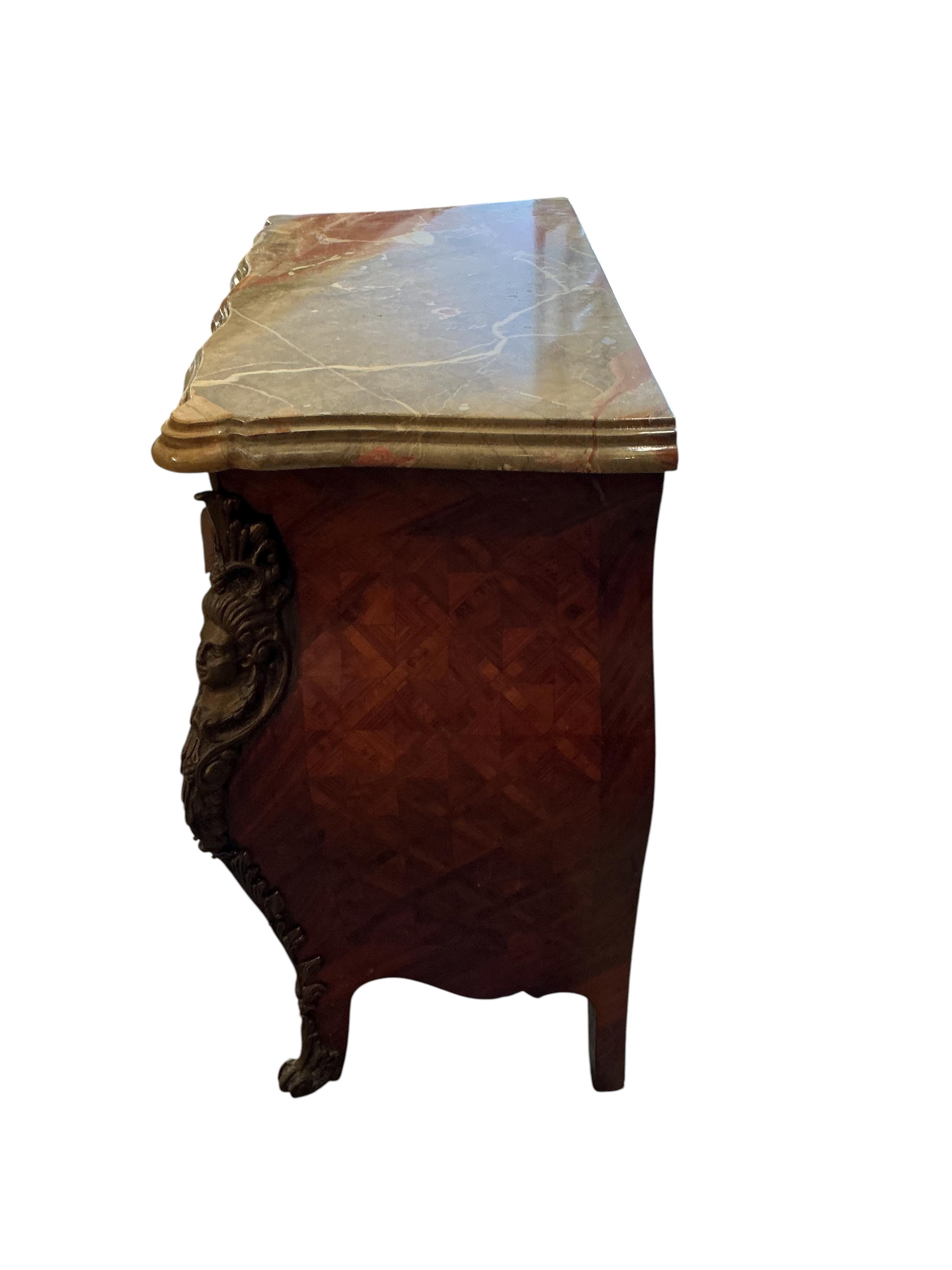 A pair of French transitional style bombe gilt metal mounted onyx top three drawer bedside chests, width 61cm, depth 33cm, height 71cm